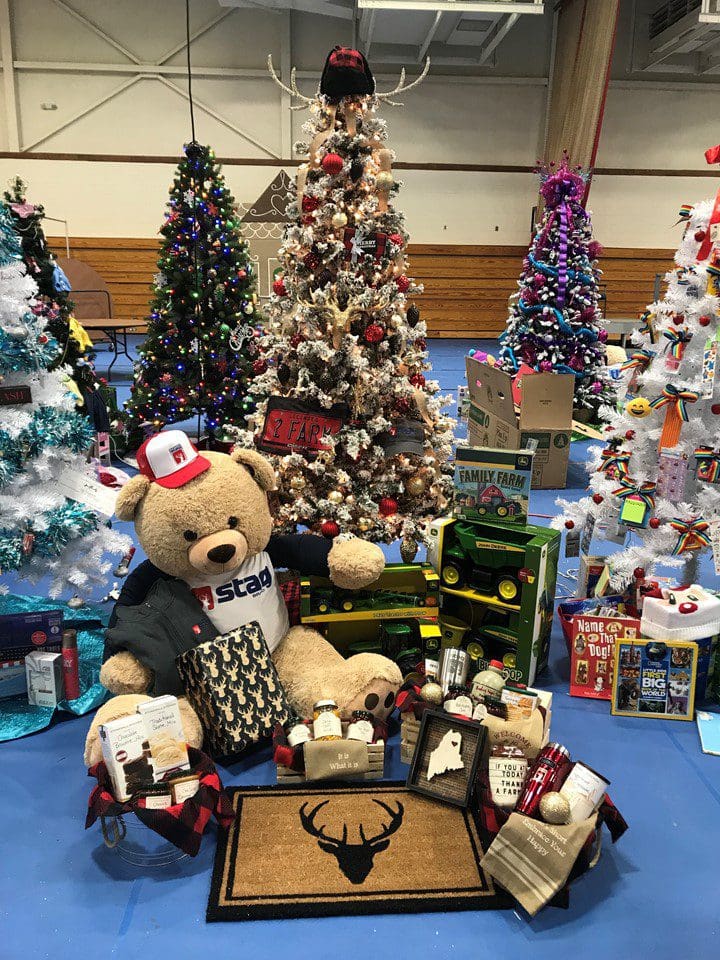 Festival of Trees featuring teddy bears and Christmas trees on a blue floor.