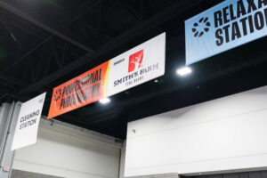 Banners hang from the ceiling displaying "Professional Photography," "Smith's Farm Stag Barn," "Relaxation Station," and "Cleaning Station.